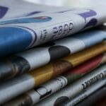 Stos kolorowych gazet na drewnianym stole, przykład druku offsetowego