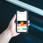 Dłoń trzymająca smartfon z aplikacją do zamawiania jedzenia