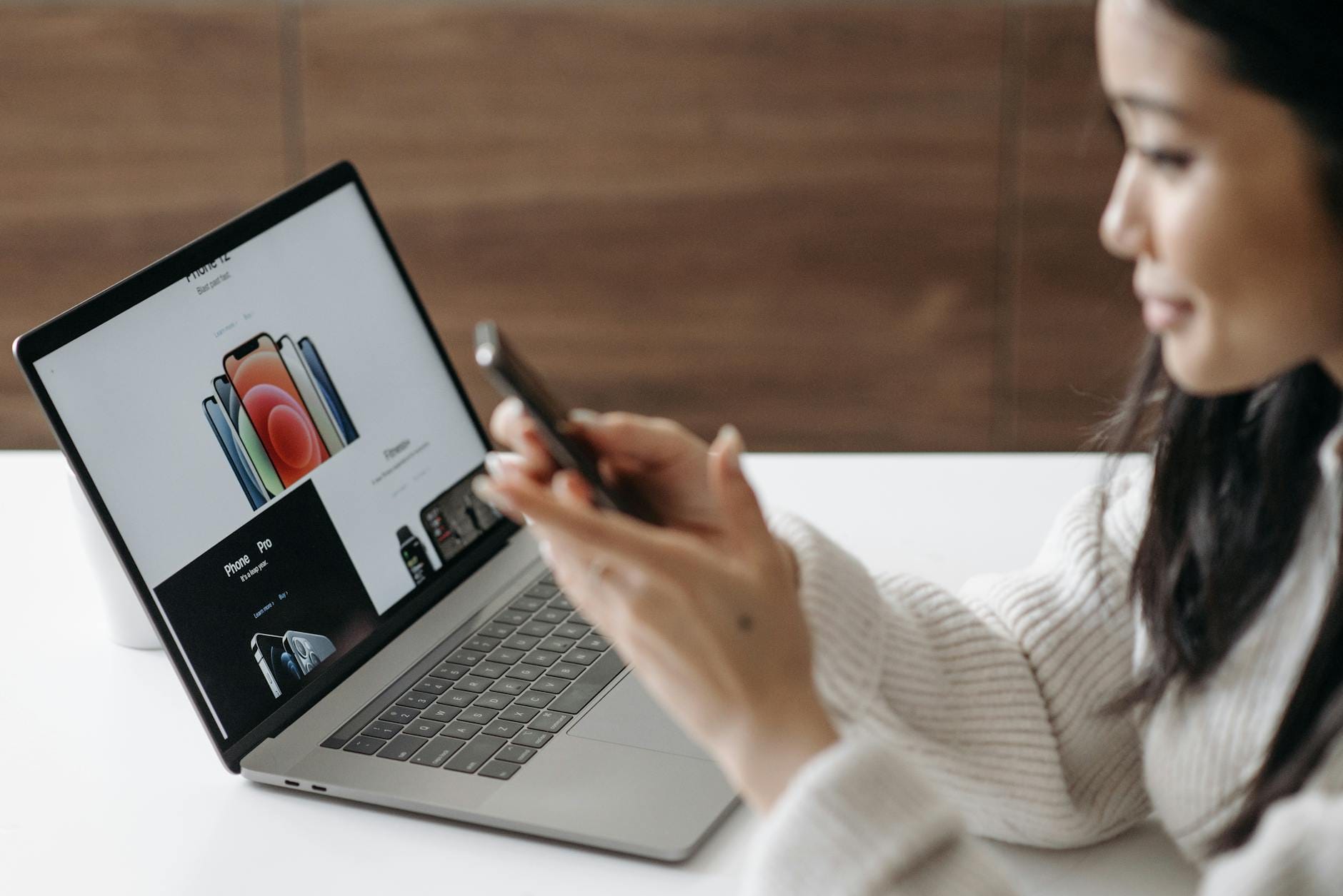 Azjatka przegląda karty produktów na laptopie i smartfonie w domu