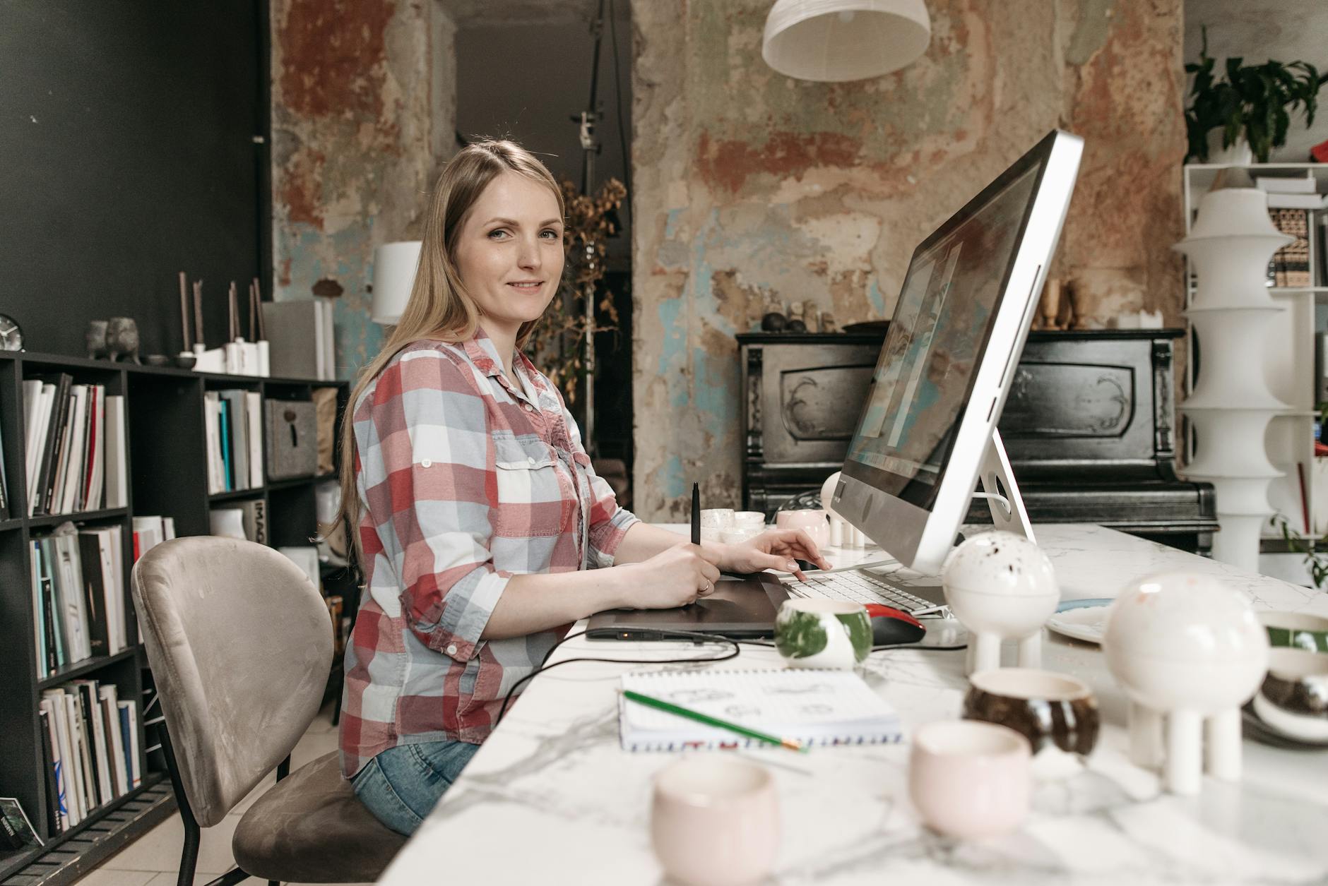 Młoda projektantka w koszuli w kratę pracuje nad profilem LinkedIn