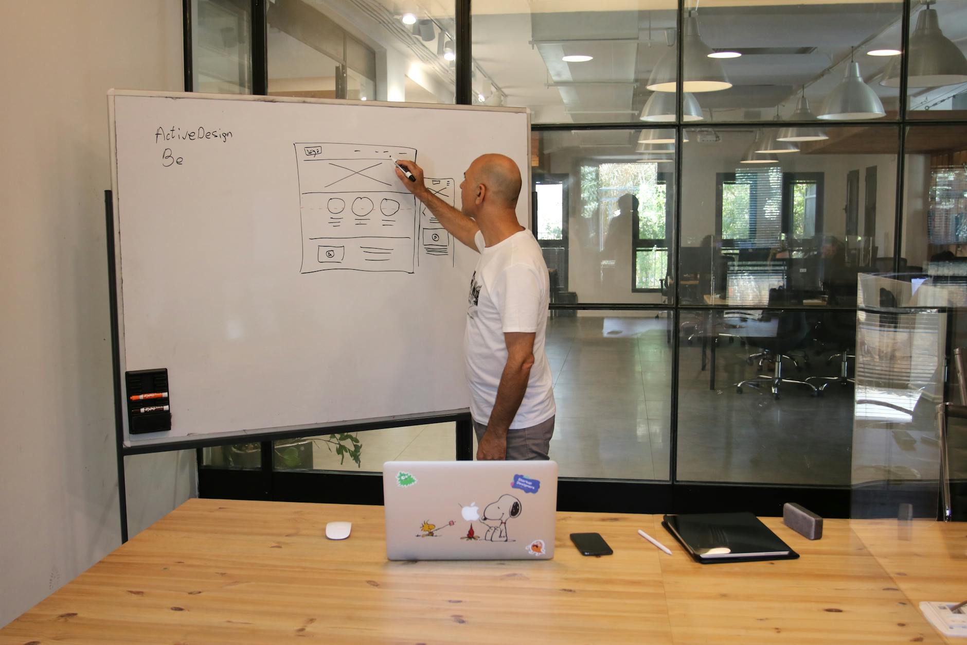 Projektant UX szkicuje strategię produktu na białej tablicy w biurze