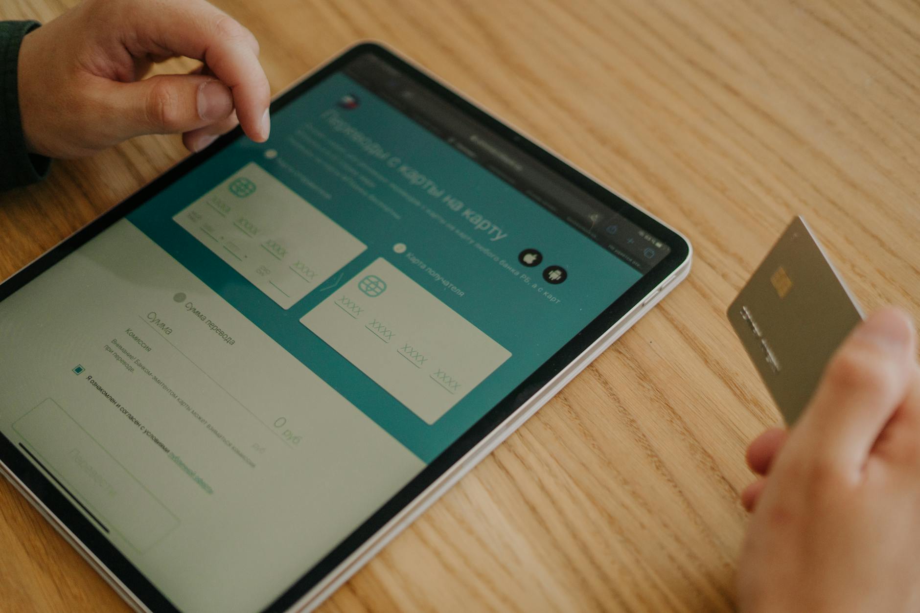 Zakupy online na tablecie z użyciem karty płatniczej na drewnianym stole