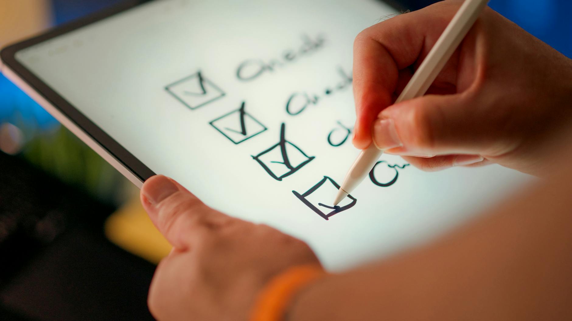 Zbliżenie na tablet z checklistą zaznaczaną rysikiem
