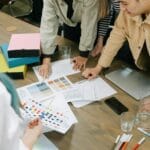 Zespół grafików omawia projekt i palety kolorów przy biurku